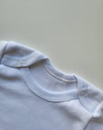 LOT 4 BODIES BLANCS BÉBÉ – MANCHES LONGUES – PRESSIONS PRATIQUES – DÈS 1 MOIS