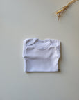LOT 4 BODIES BLANCS BÉBÉ – MANCHES LONGUES – PRESSIONS PRATIQUES – DÈS 1 MOIS